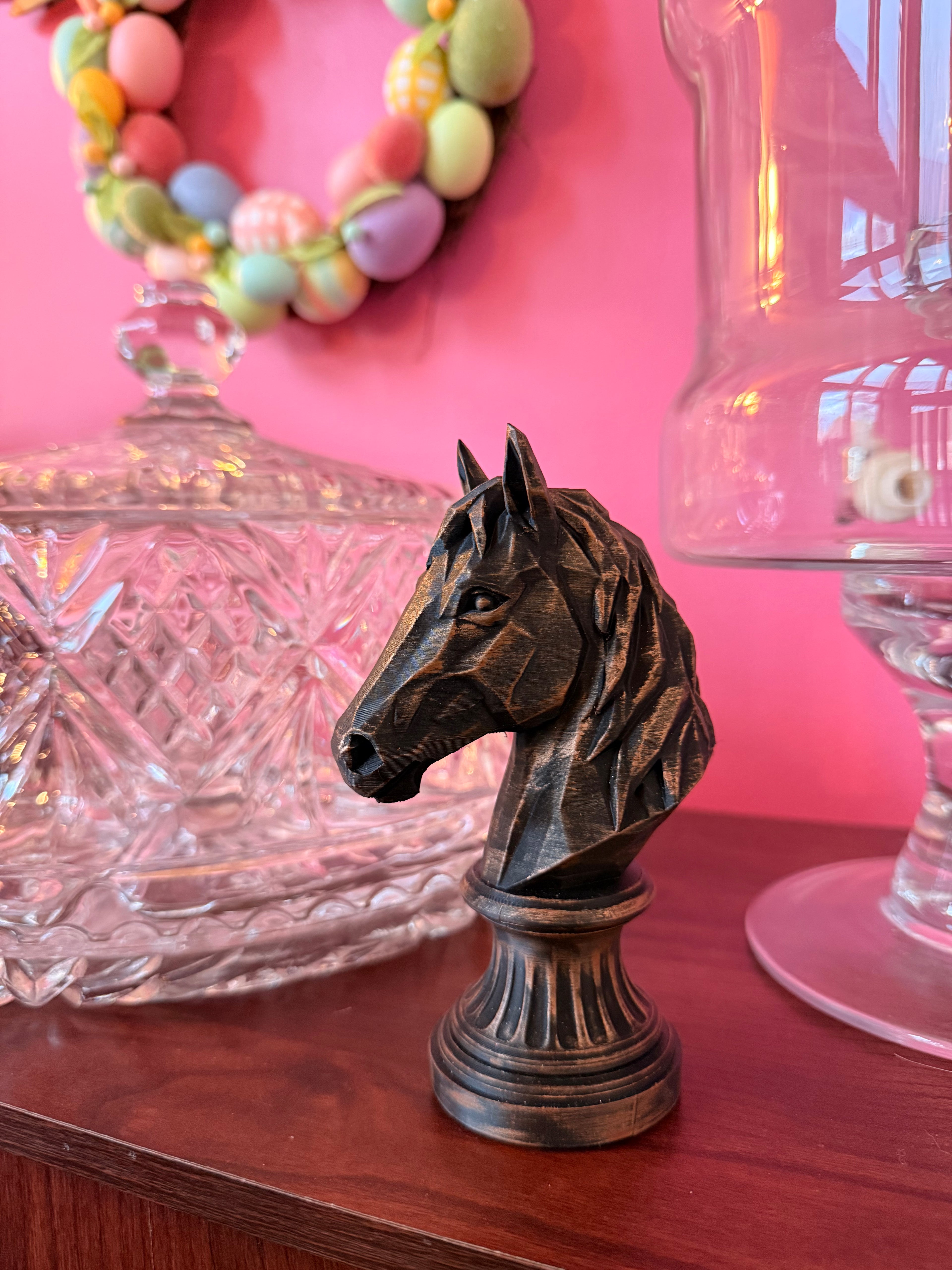 Bronze-finish geometric horse bust displayed on a dresser with glassware and spring décor.